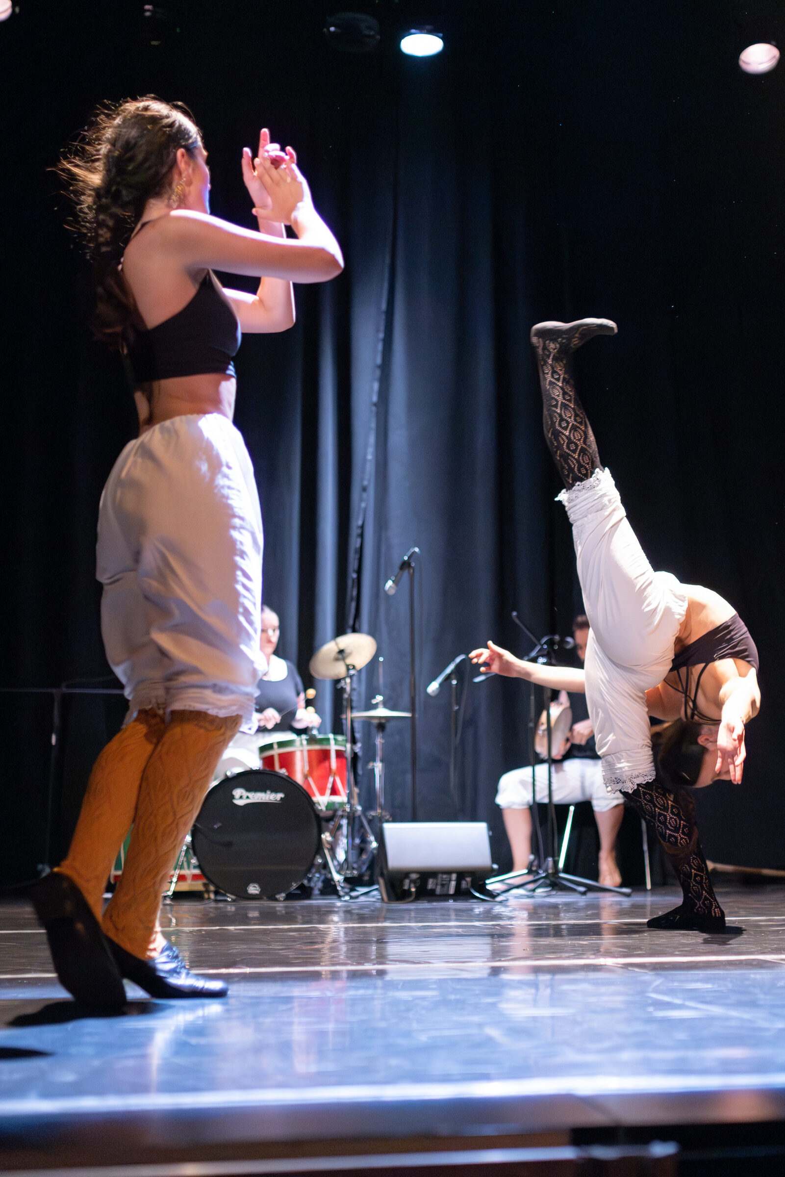 Bailarinas en movemento contemporáneo, unha delas facendo o pino
