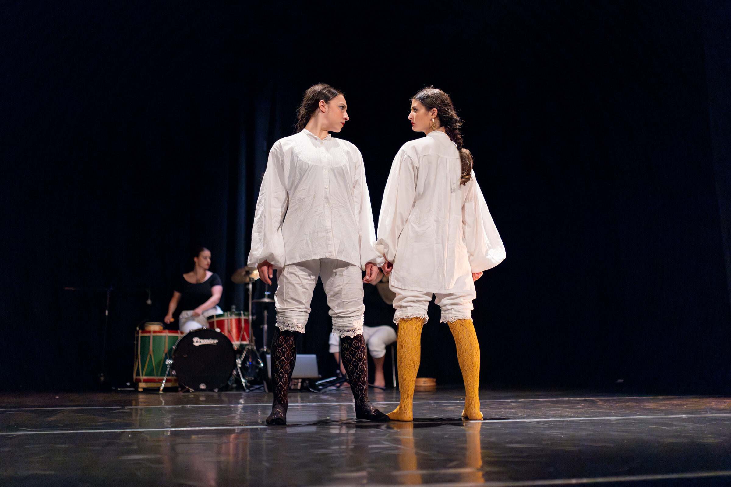 Dúo de bailarinas con camisa branca e medias amarelas fronte a fronte
