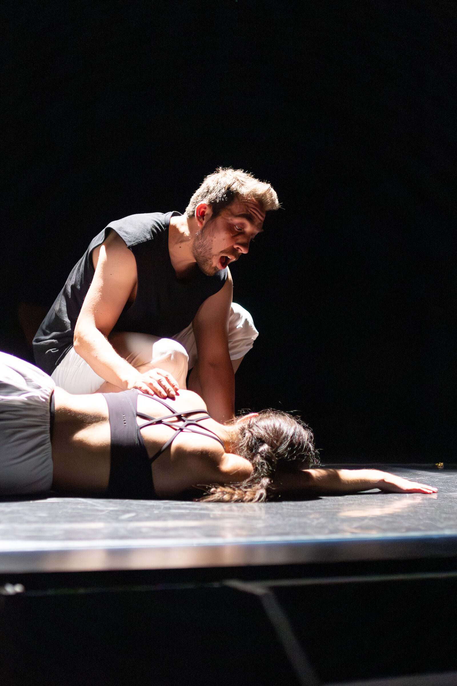Bailarín e bailarina nunha escena íntima sobre o chan do escenario