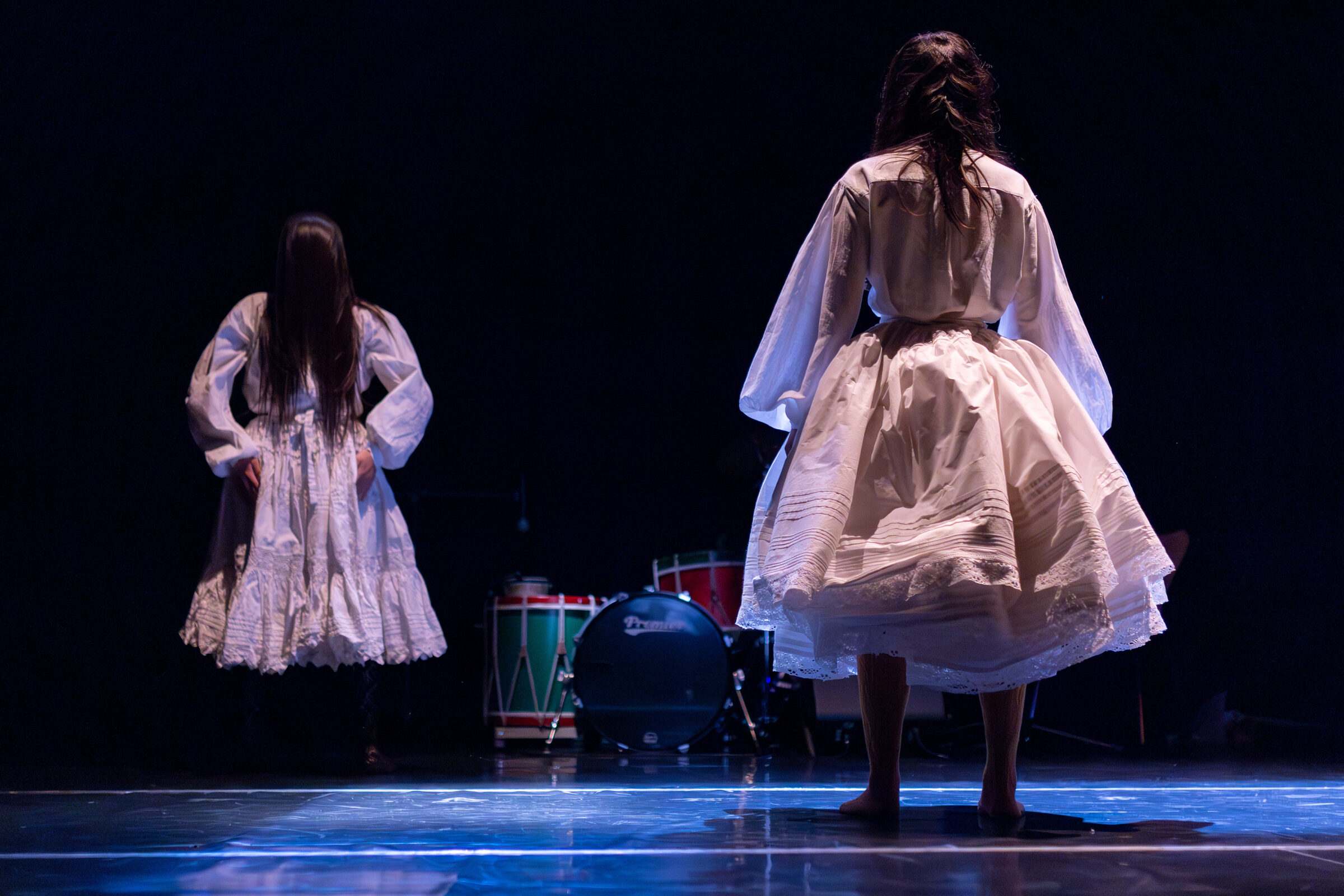 Dúas bailarinas con traxe tradicional galego de costas ao público en "O que non se ve"